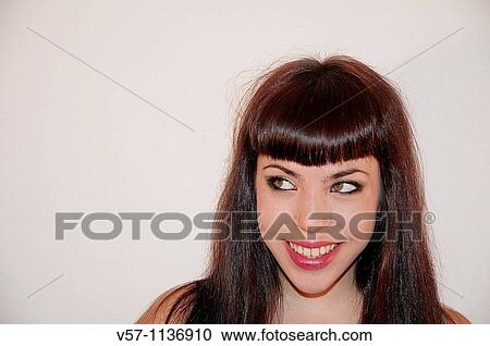 Stock Image - Young woman smiling and looking up. Close view.. Fotosearch