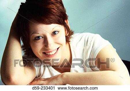 Stock Image - Young woman smiling at camera. Fotosearch