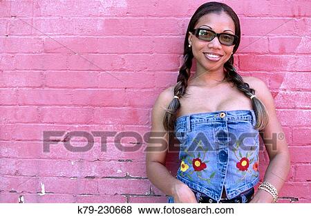 Young woman smiling at wearing sunglasses. View Large Photo Image Stock Photo - Young woman smiling at wearing sunglasses.. Fotosearch