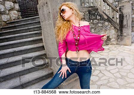 Young woman spreading magenta-colored shirt, medieval Mediterranean architecture building with stone staircase View Large Photo Image Stock Photo - Young woman spreading magenta-colored shirt, medieval Mediterranean architecture building with stone staircase. Fotosearch