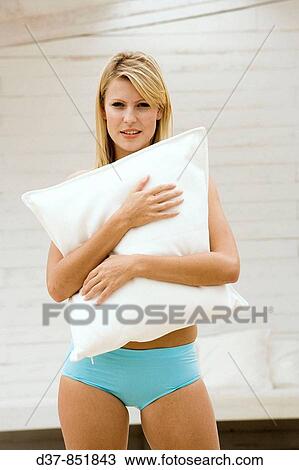 Stock Image - Young woman standing at home. Fotosearch
