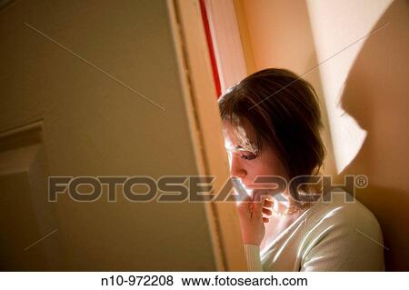 Young woman standing by her front door View Large Photo Image Stock Photo - Young woman standing by her front door. Fotosearch