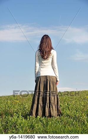 Young woman standing in field, raer view View Large Photo Image Stock Image - Young woman standing in field, raer view. Fotosearch