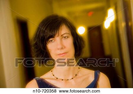 Stock Photo - Young woman standing in her apartment hallway.. Fotosearch