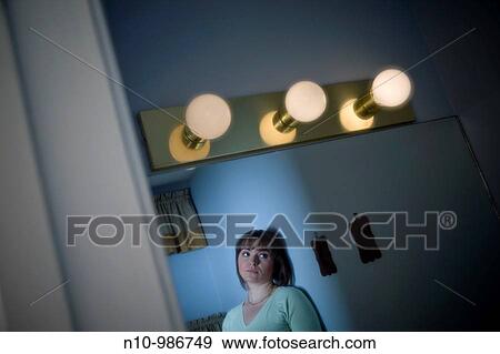 Young woman standing in her bathroom View Large Photo Image Stock Photo - Young woman standing in her bathroom. Fotosearch