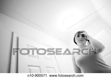 Young woman standing in the hallway of her house. View Large Photo Image Stock Image - Young woman standing in the hallway of her house.. Fotosearch