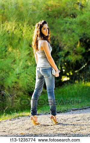 Picture - Young woman standing in the park. Fotosearch