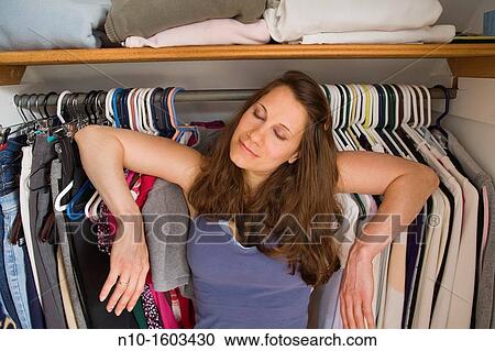 Young woman standing inside her closet View Large Photo Image Stock Image - Young woman standing inside her closet. Fotosearch