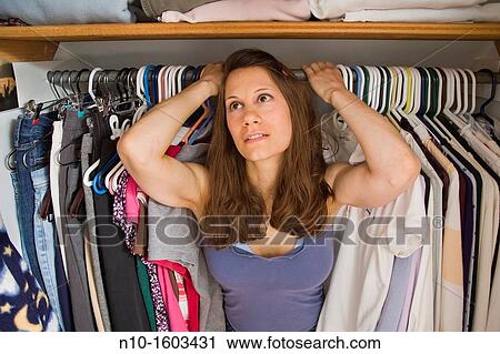 Young woman standing inside her closet View Large Photo Image Stock Image - Young woman standing inside her closet. Fotosearch