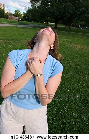 Stock Photo - Young woman, standing on the grass at a park, dramatically gesturing.. Fotosearch