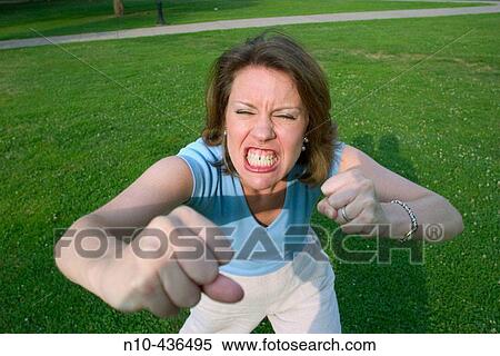 Young woman, standing on the grass at a park, pretending to be duking" it out. " View Large Photo Image Stock Photography - Young woman, standing on the grass at a park, pretending to be duking" it out. ". Fotosearch
