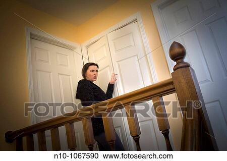 Young woman standing on the landing in her house View Large Photo Image Stock Image - Young woman standing on the landing in her house. Fotosearch