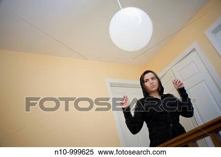 Young woman standing on the landing in her house View Large Photo Image Stock Photography - Young woman standing on the landing in her house. Fotosearch