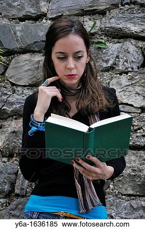 Young woman standing outdoors reading book View Large Photo Image Stock Photography - Young woman standing outdoors reading book. Fotosearch