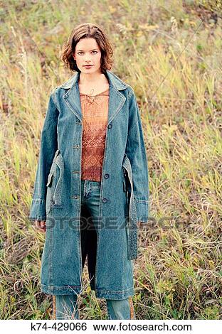 Stock Photograph - Young Woman Standing Outside In Field. Fotosearch