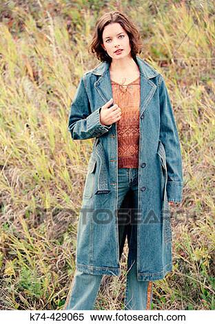 Stock Photography - Young Woman Standing Outside In Field. Fotosearch