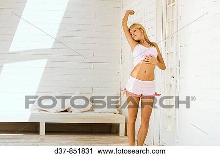 Young woman stretching at home in the morning View Large Photo Image Stock Image - Young woman stretching at home in the morning. Fotosearch