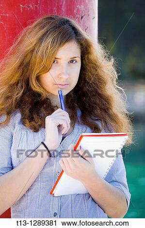 Young woman student with a paper notebook in hand View Large Photo Image Stock Image - Young woman student with a paper notebook in hand. Fotosearch