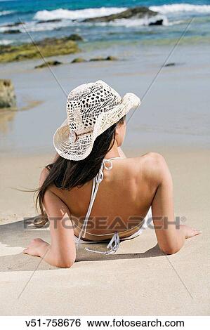 Stock Photograph - Young woman sunbathing in the beach. Fotosearch