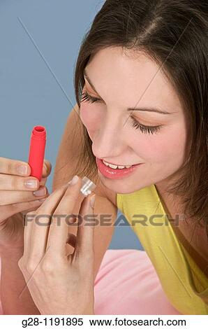Young woman taking homeopathy tablets out of a red tube View Large Photo Image Stock Photography - Young woman taking homeopathy tablets out of a red tube. Fotosearch