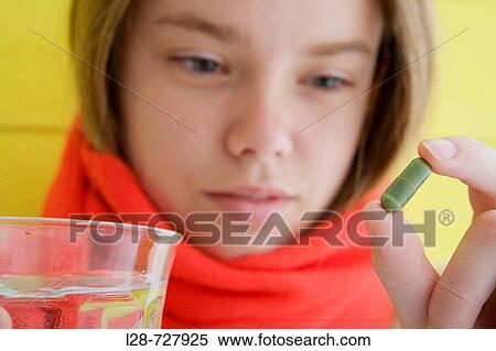 young woman taking pill, studio shot View Large Photo Image Stock Photography - young woman taking pill, studio shot. Fotosearch
