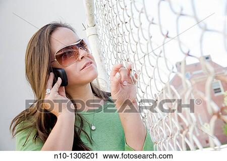 Young woman talking on her cell phone View Large Photo Image Stock Image - Young woman talking on her cell phone. Fotosearch