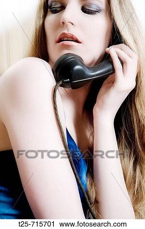 Stock Image - Young woman talking on phone. Fotosearch