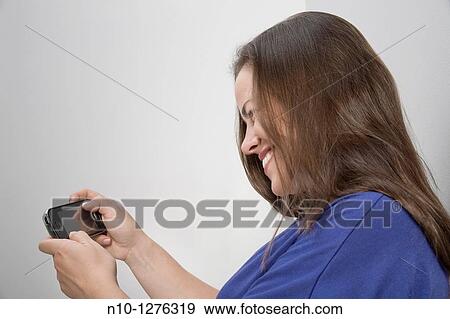 Young woman texting on her cell phone View Large Photo Image Stock Photo - Young woman texting on her cell phone. Fotosearch