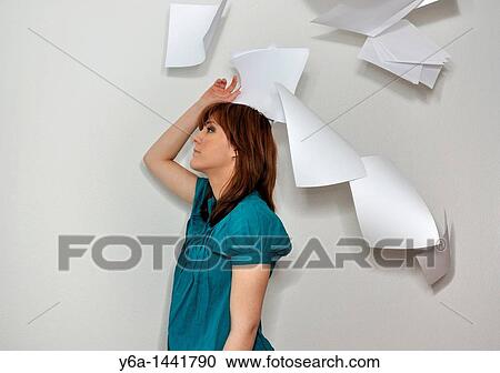 Stock Image - Young woman throwing paperwork in air. Fotosearch
