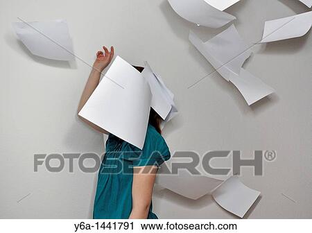 Stock Image - Young woman throwing paperwork in air. Fotosearch