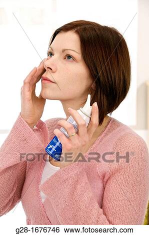 Young woman using a sea water nose spray View Large Photo Image Stock Photograph - Young woman using a sea water nose spray. Fotosearch