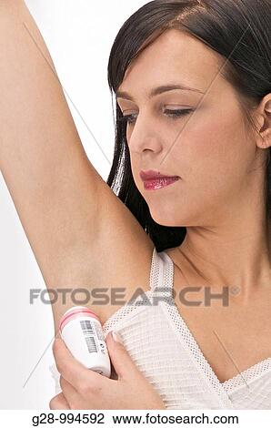 young woman using deodorant in her bathroom View Large Photo Image Stock Image - young woman using deodorant in her bathroom. Fotosearch