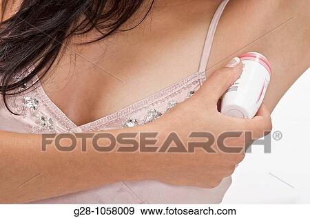young woman using deodorant in her bathroom close up View Large Photo Image Stock Photo - young woman using deodorant in her bathroom close up. Fotosearch