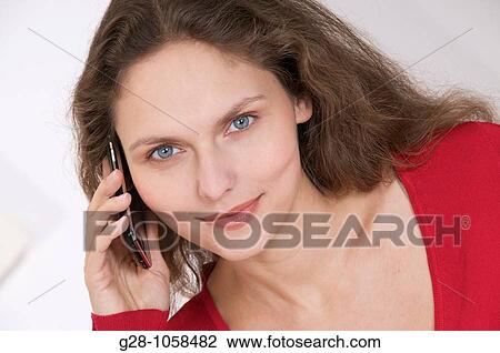 young woman using her Iphone and smiling View Large Photo Image Stock Image - young woman using her Iphone and smiling. Fotosearch