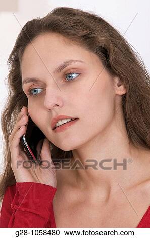 Stock Image - young woman using her Iphone and looking worried. Fotosearch