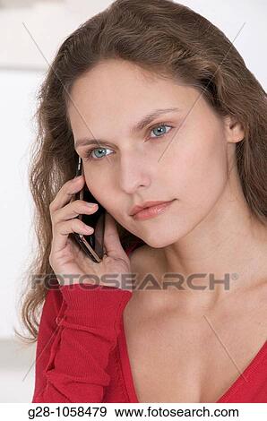 Stock Photo - young woman using her Iphone. Fotosearch