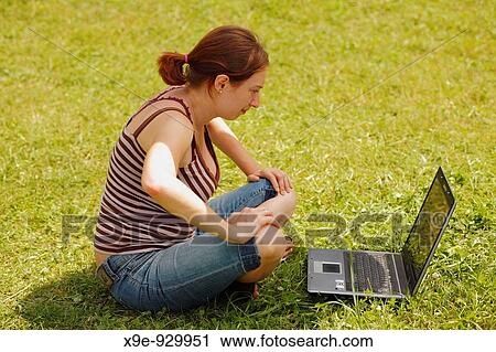 Young woman using her laptop outdoors View Large Photo Image Stock Image - Young woman using her laptop outdoors. Fotosearch