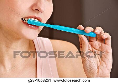 young woman using her toothbrush in the bathroom for tooth hygiene View Large Photo Image Stock Image - young woman using her toothbrush in the bathroom for tooth hygiene. Fotosearch