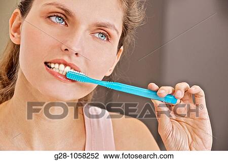 young woman using her toothbrush in the bathroom for tooth hygiene View Large Photo Image Stock Image - young woman using her toothbrush in the bathroom for tooth hygiene. Fotosearch