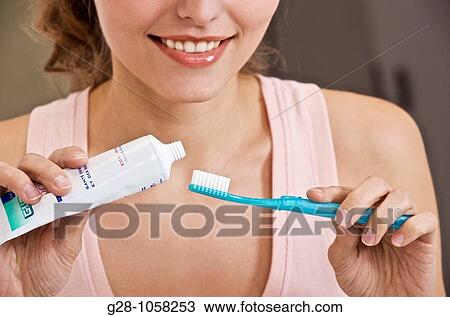 young woman using her toothpaste and toothbrush in the bathroom for tooth hygiene View Large Photo Image Stock Image - young woman using her toothpaste and toothbrush in the bathroom for tooth hygiene. Fotosearch