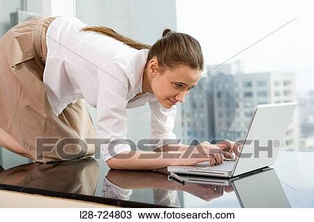 Stock Image - Young woman using laptop. Fotosearch