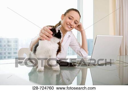 Young woman using laptop with kitten View Large Photo Image Stock Image - Young woman using laptop with kitten. Fotosearch