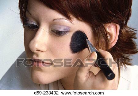 Young woman using makeup View Large Photo Image Stock Image - Young woman using makeup. Fotosearch