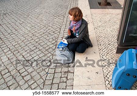 Stock Photo - young woman waiting for the bus in Lisbon, Portugal. Fotosearch