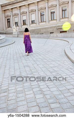 Young woman walking on Cobblestone Street leading to parliament building of Vienna View Large Photo Image Stock Photo - Young woman walking on Cobblestone Street leading to parliament building of Vienna. Fotosearch