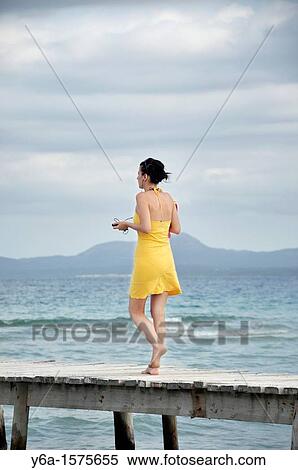 Young woman walking on wooden pier, Alcudia, Mallorca, Spain, Europe View Large Photo Image Stock Photography - Young woman walking on wooden pier, Alcudia, Mallorca, Spain, Europe. Fotosearch