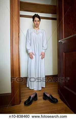 Young woman, wearing a nightgown, standing in her empty bedroom closet. View Large Photo Image Stock Image - Young woman, wearing a nightgown, standing in her empty bedroom closet.. Fotosearch