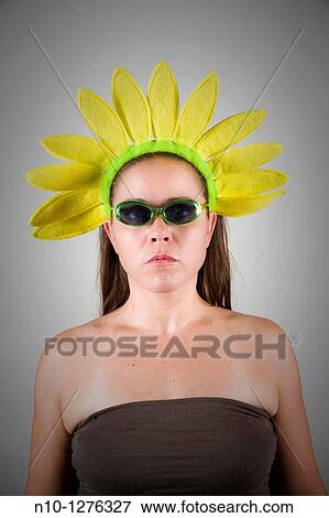 Young woman wearing a sunflower hat and sunglasses View Large Photo Image Stock Photo - Young woman wearing a sunflower hat and sunglasses. Fotosearch