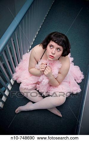 Young woman wearing a tutu and sitting on the floor outside her apartment. View Large Photo Image Stock Image - Young woman wearing a tutu and sitting on the floor outside her apartment.. Fotosearch