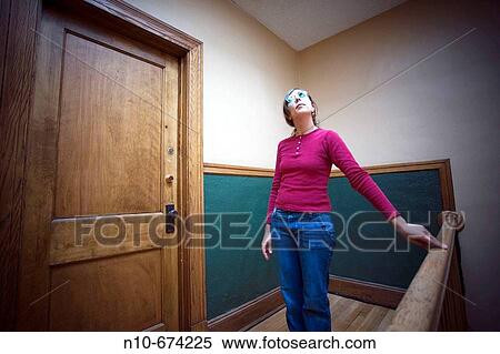 Young woman, wearing blue sunglasses, posing in the hallway of her apartment building. View Large Photo Image Stock Photography - Young woman, wearing blue sunglasses, posing in the hallway of her apartment building.. Fotosearch